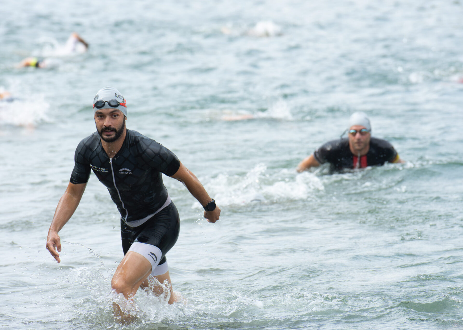 Einfahrt Rennräder mit Triathleten in die Wechselzone Balgach
